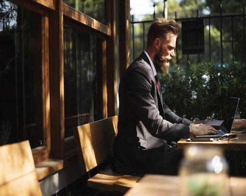 Person working responsibly on a laptop during afternoon hours with soft lateral window lighting