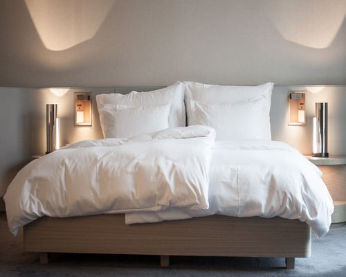 Comfortable cozy room setup showing a neat bed and a soft nightstand lamp illuminated