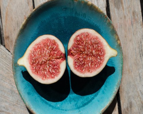 Slices of fresh organic papaya and ripe yellow mango arranged beautifully on a plate